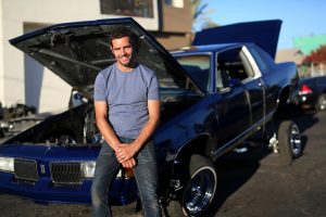 Marc "Elvis" Priestley, host of the Discovery Channel's Driving Wild, interacts with members of a Low Rider Club while filming  in Mexicali, Mexico on Saturday, November 7, 2015.